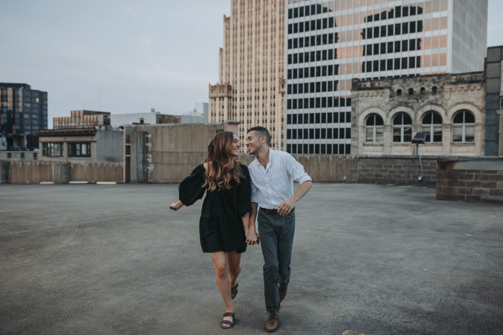 downtown memphis engagement photos, a couple runs and flirts on a parking garage rooftop in downtown memphis, tn.