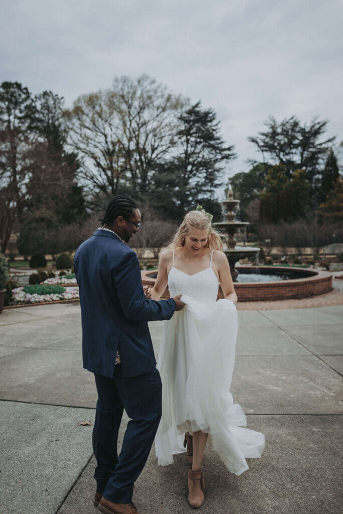A newly eloped couple walks together by the fountain at Memphis Botanic Gardens, photographed by Wandering Creative