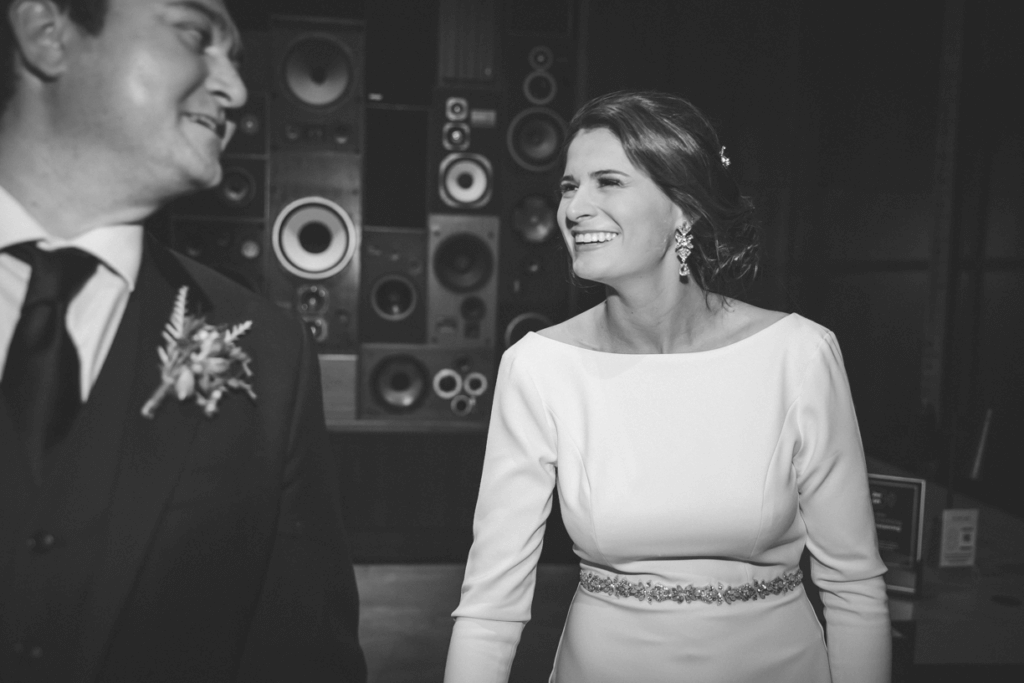 newlywed couple smiles at each other as they walk in front of the vinyl wall at Central Station Hotel in Memphis, TN