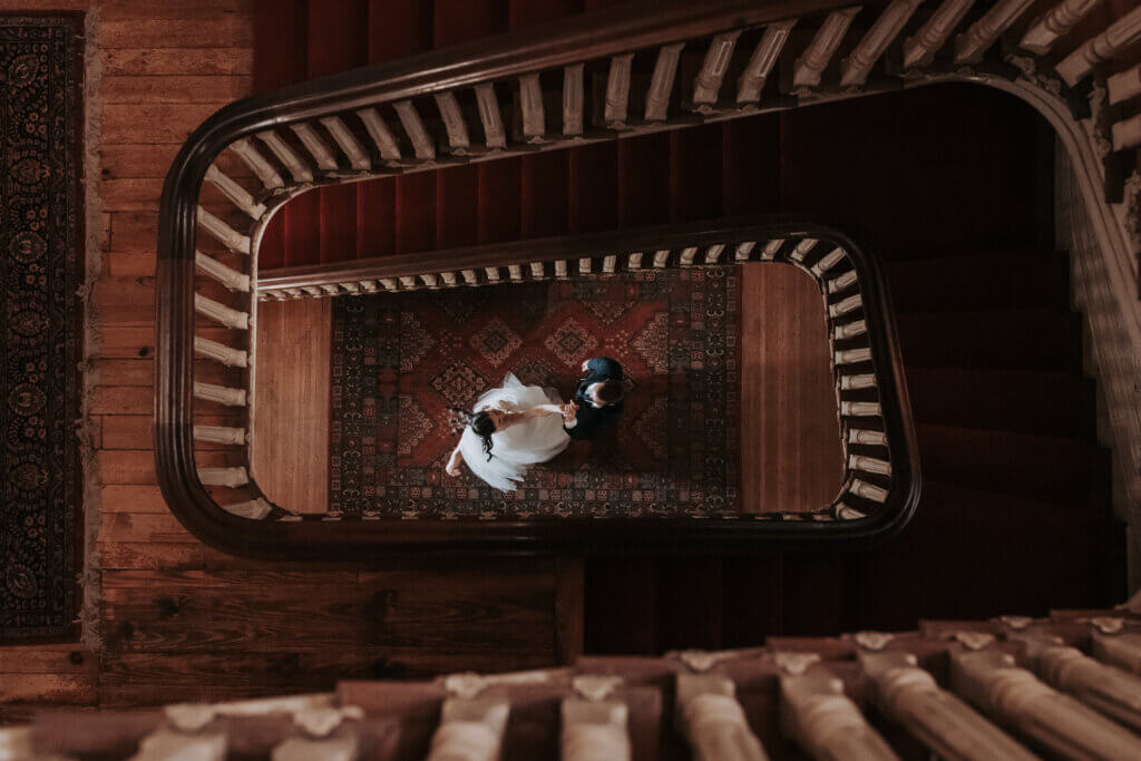 A photo of a bride and groom dancing on the first floor, shot from the third floor of the Woodruff Fontaine House.