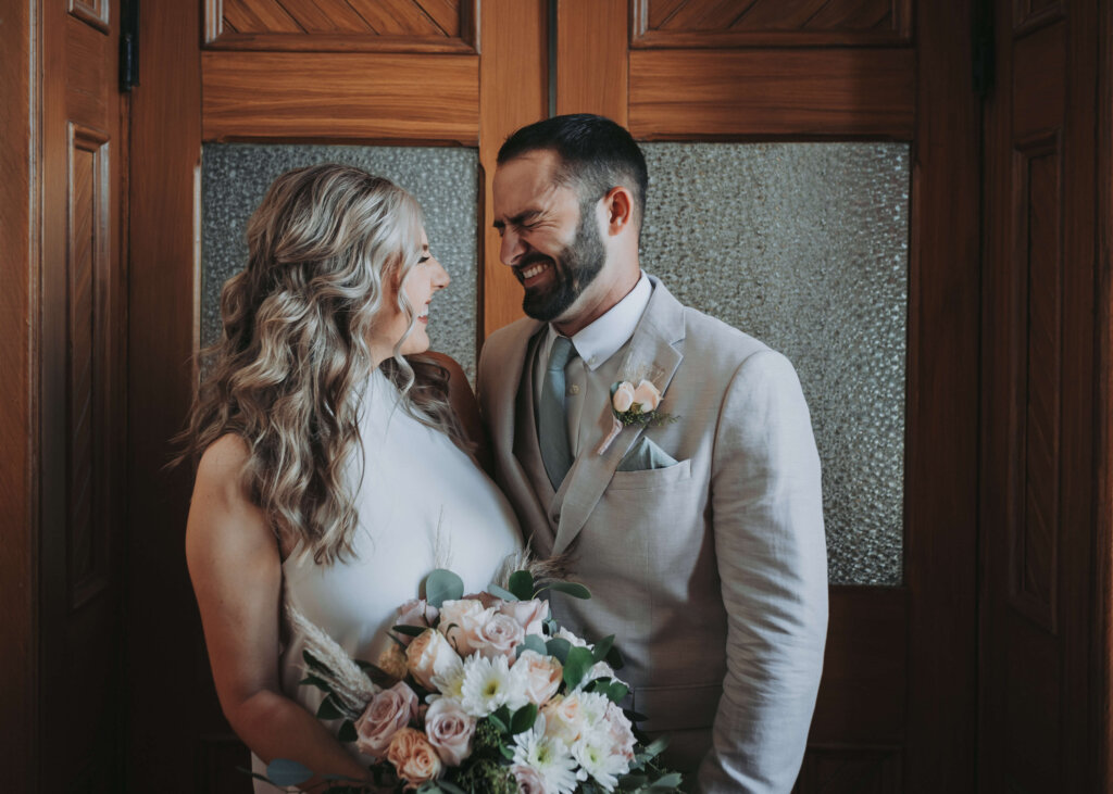 a couple stands together, laughing, before their intimate elopement. photographed by wandering creative Chicago Elopement Venues